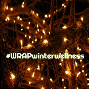 twinkle lights on a tree branch with text across that says hashtag WRAP winter wellness